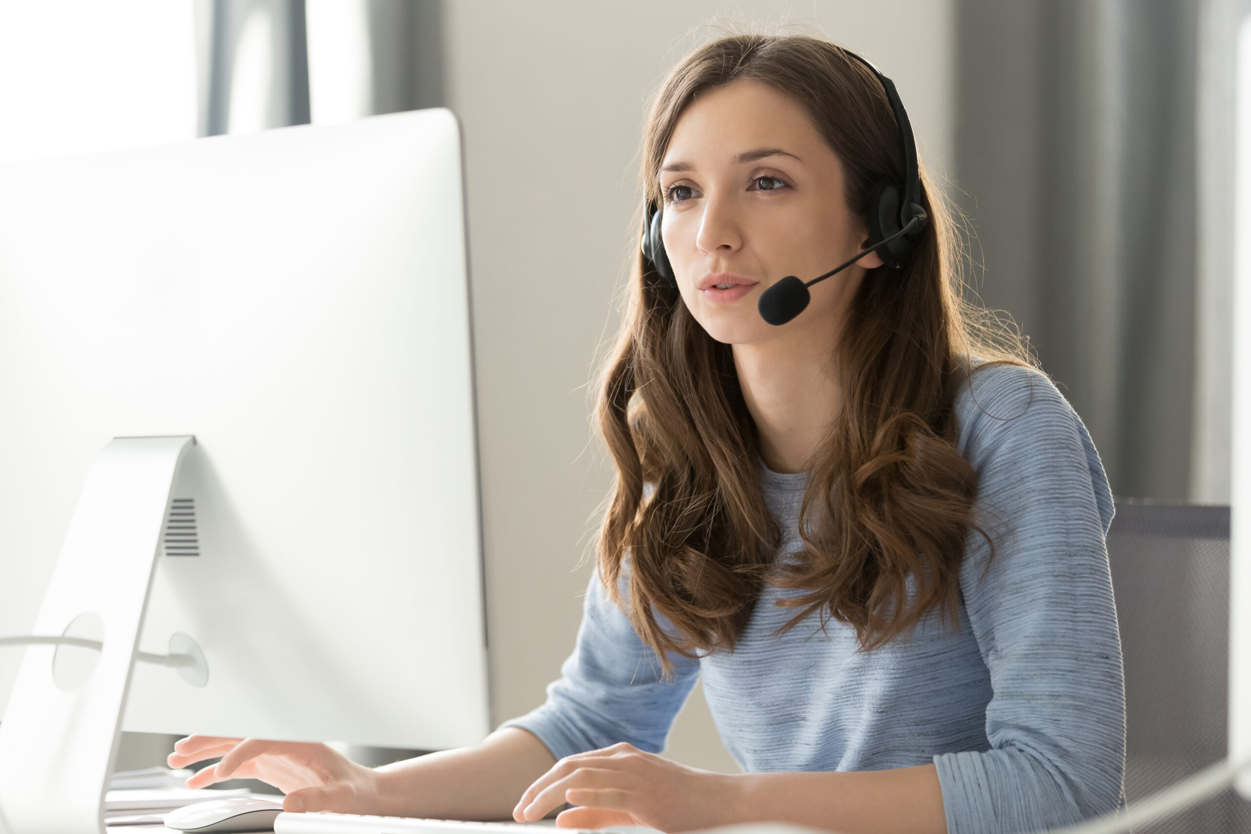 Medewerker meldcentrale spreekt met klant door headset